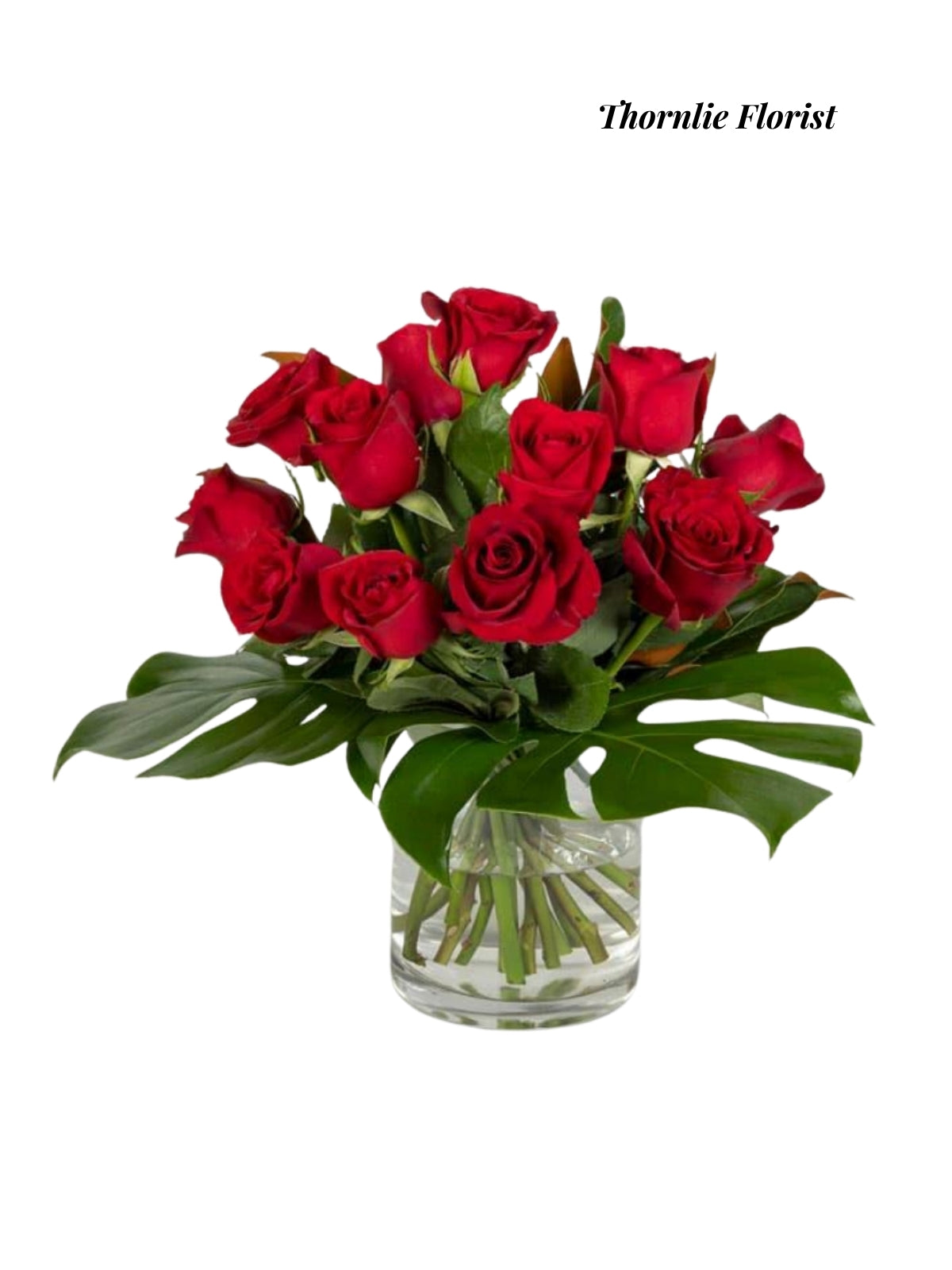 Crimson Elegance: A beautiful bouquet of deep red roses and lush green leaves in a glass vase.