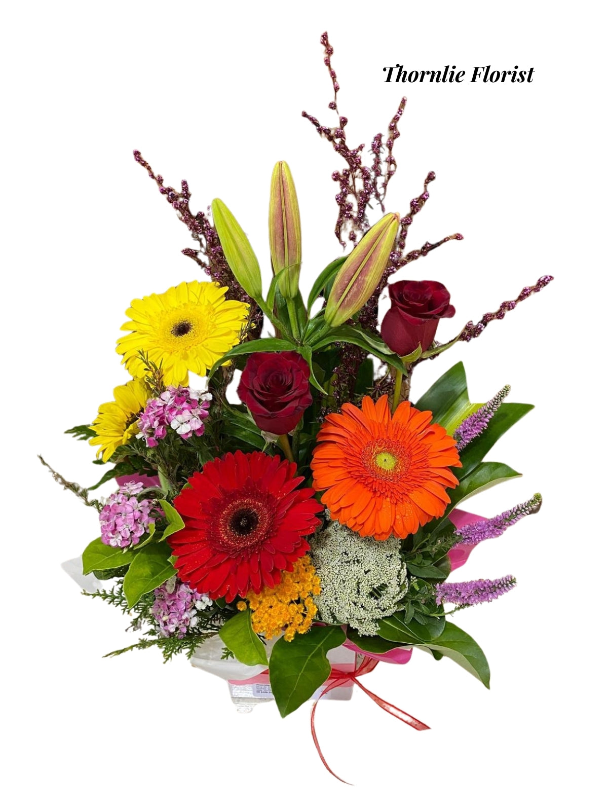 Radiant Charm flower arrangement with red roses, yellow and orange gerberas, and lilies.