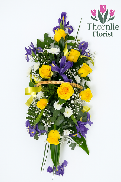 Golden Farewell funeral flower arrangement with yellow roses and purple irises in a basket.