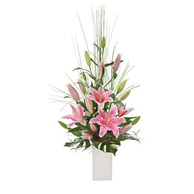 Elegant Panache Flowers arrangement with pink lilies and tall grasses in a white vase